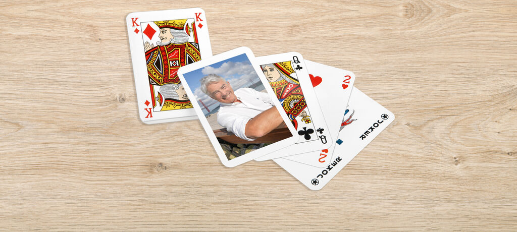 Smiling man relaxing with playing cards on the table