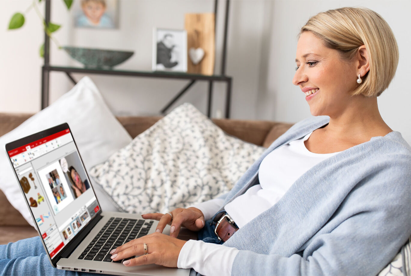 A person working on a laptop creating a CEWE photo book. Their style is casual, sitting on a sofa.