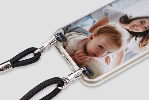 A person holds a phone with a snapshot of a smiling child.