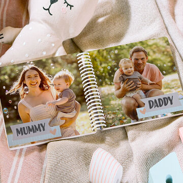 Family photo in a photo book with a child on the father's and mother's lap.
