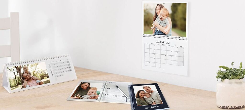 Beautiful table with creative CEWE photo calendars and photos of happy moments with family and friends