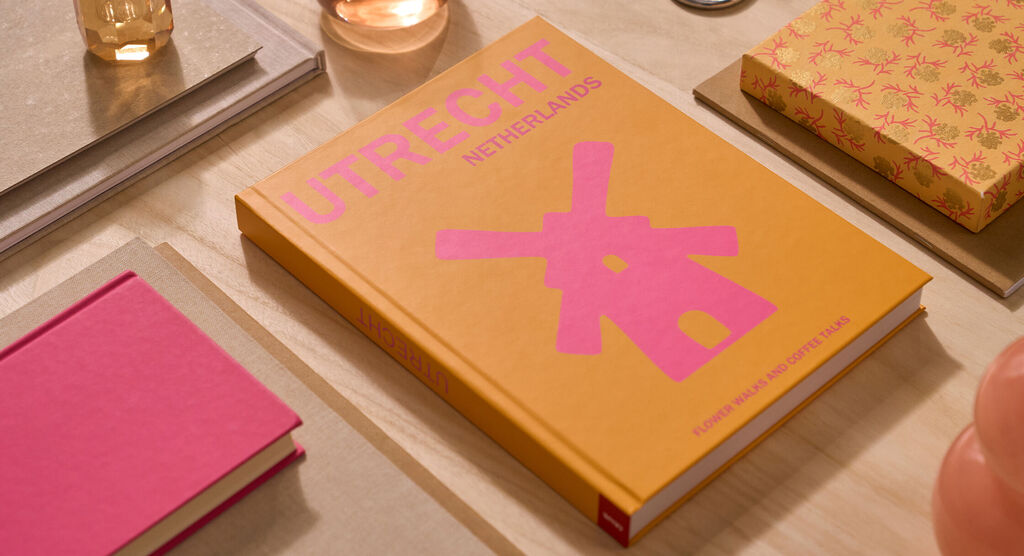 An Utrecht-themed coffee table book laying on a wooden table.
