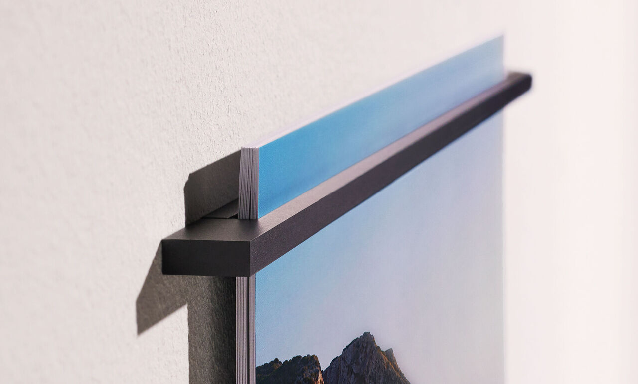 Close-up of a wall picture hanging on a wall showing the top holder.