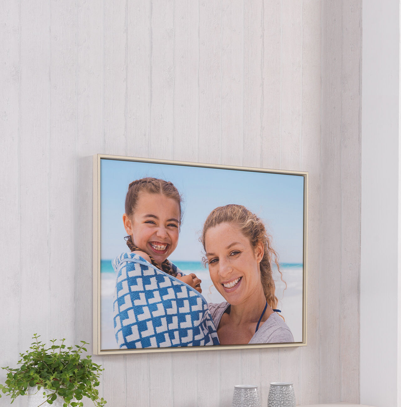 Two people on the beach holding a towel