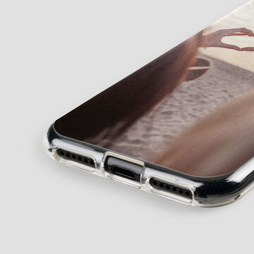 The phone lies on a table showing a beautiful photo. It is surrounded by a natural setting.