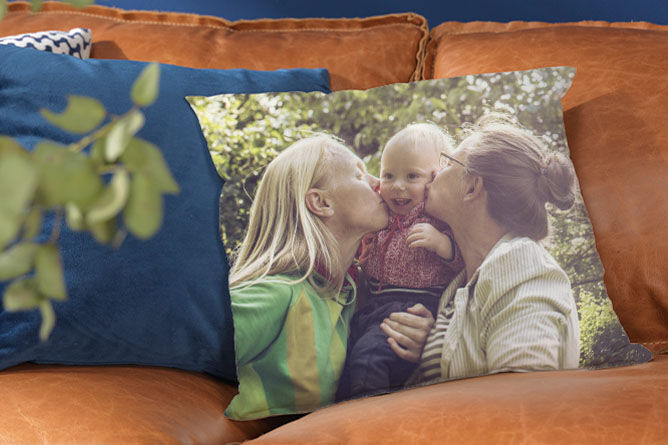 A loving hug between grandma and kids on a colorful cushion