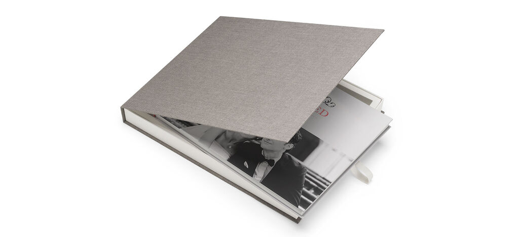 Open CEWE PHOTOBOOK with a gray cover and pictures inside