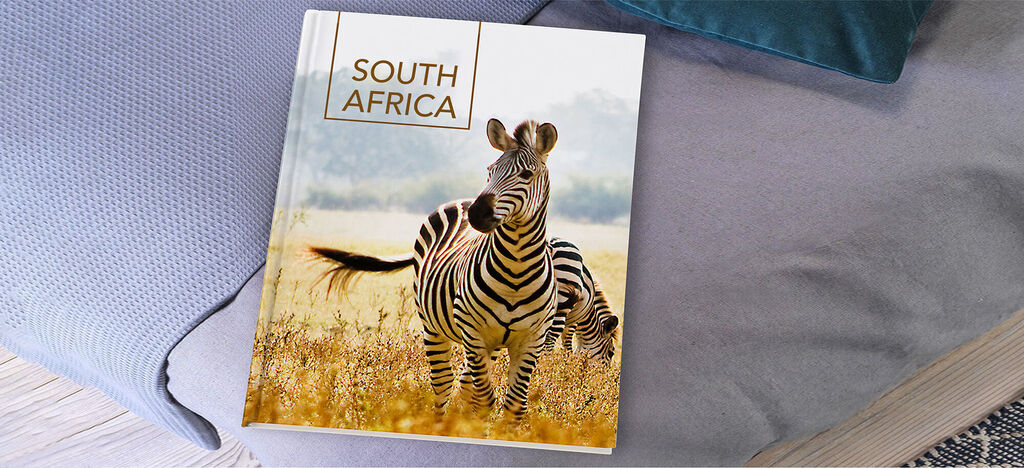Photo book with a zebra on the cover, running through a grassy landscape.
