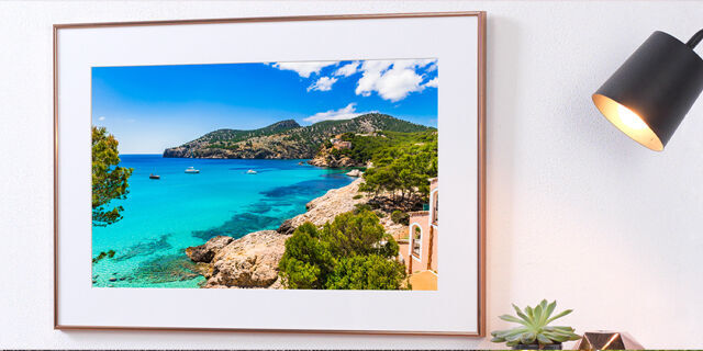 A beautiful coastal view of a picturesque bay with bright blue water and green hills in the background.