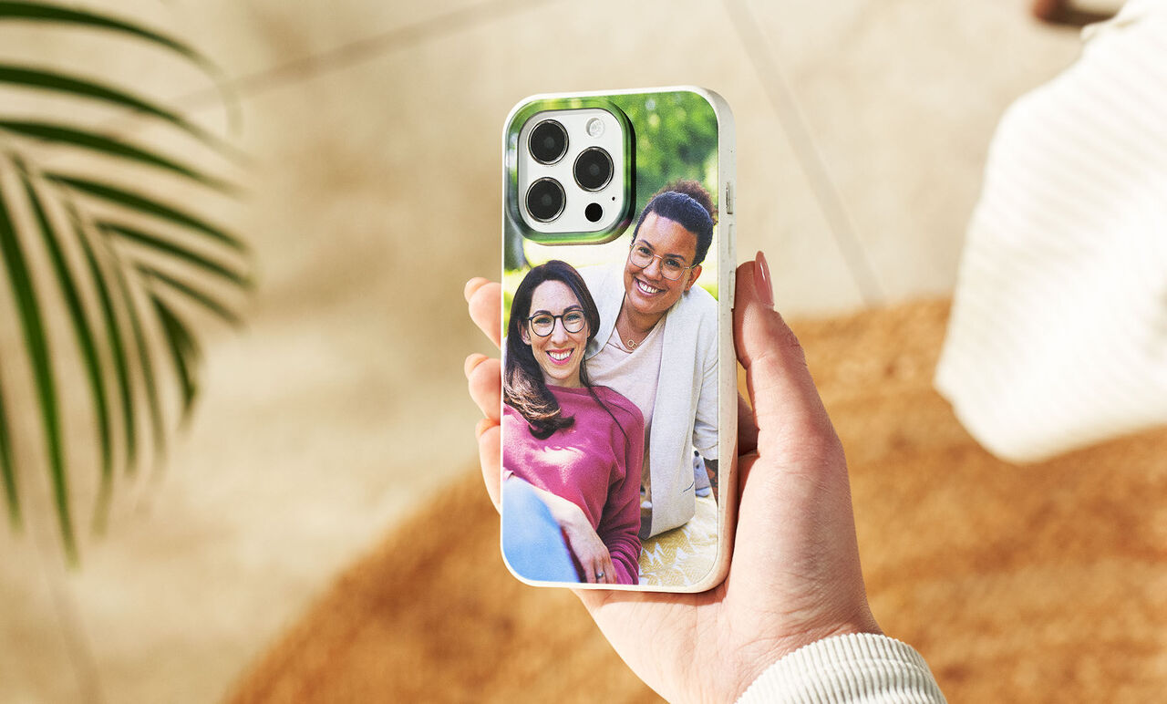A hand holding a phone with a personal photo on the back.
