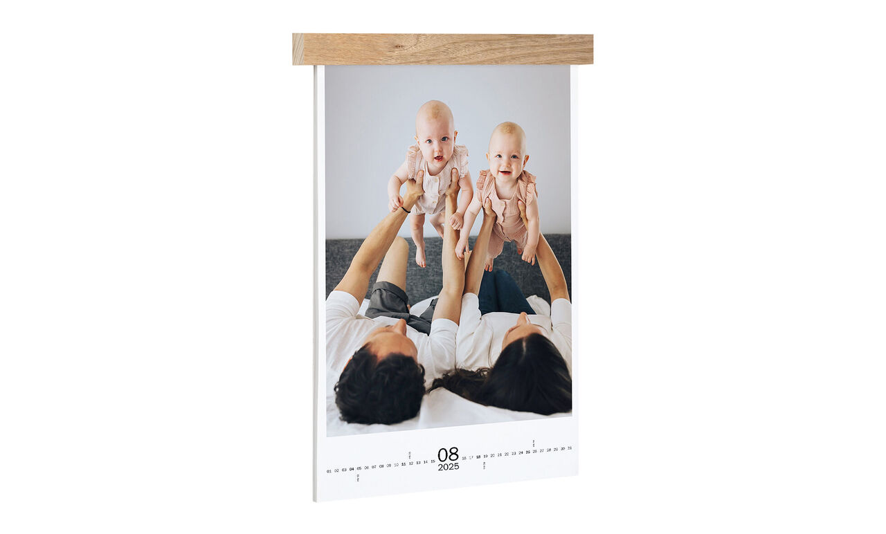 A couple holds up their twins. The photo conveys joy and happy moments.