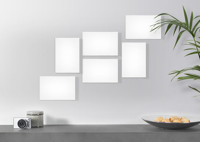 White framed picture frames on a wall, below a bowl of snacks and a camera ready for memories.