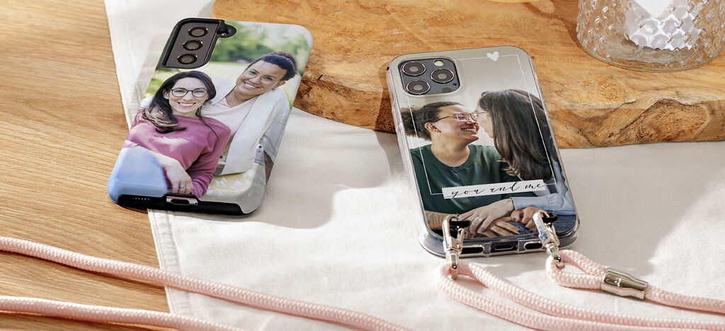 Two handmade phone cases with individual photo designs on a table.