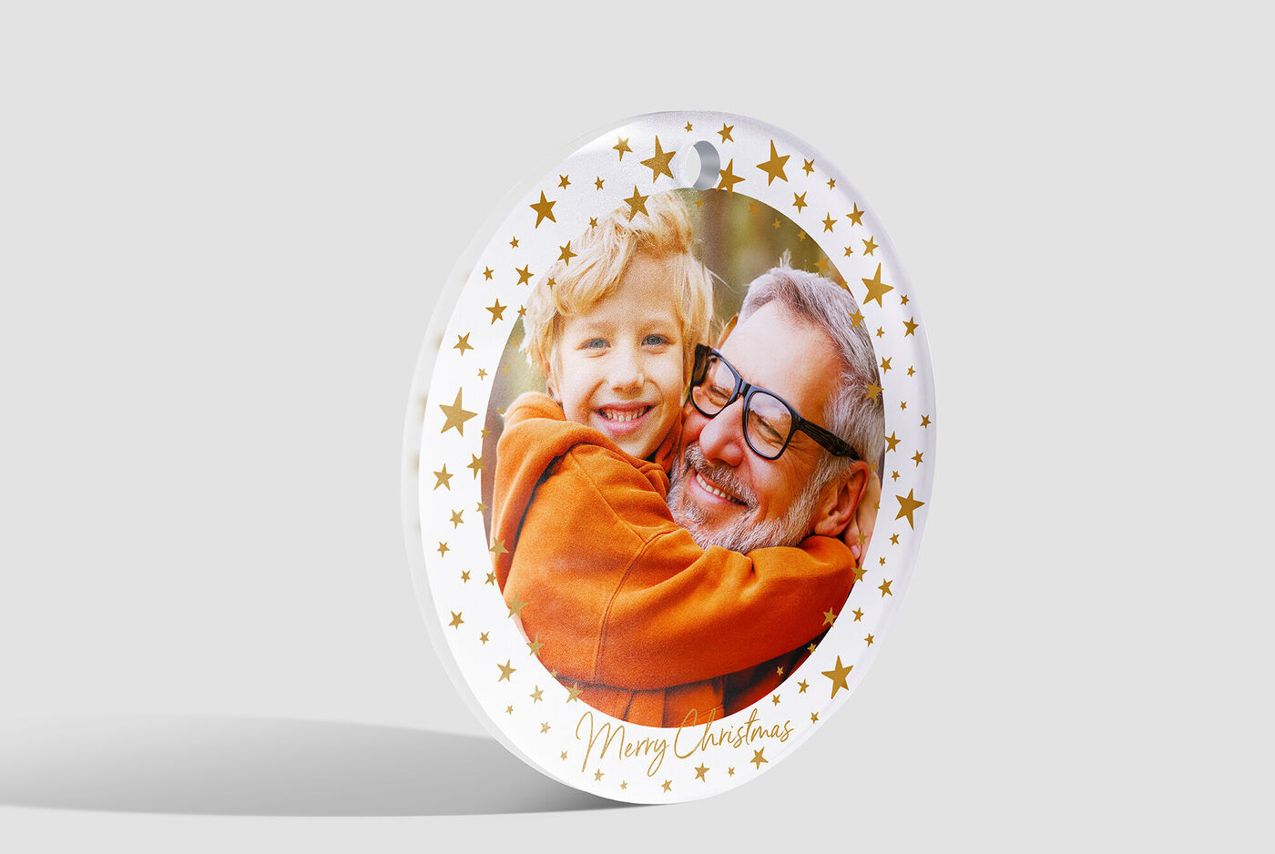 A round Christmas card with golden stars around a loving snapshot.