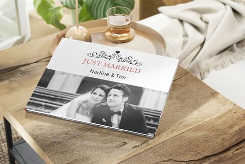 Wedding album titled "Just Married" with the names Nadine and Tim on a table.