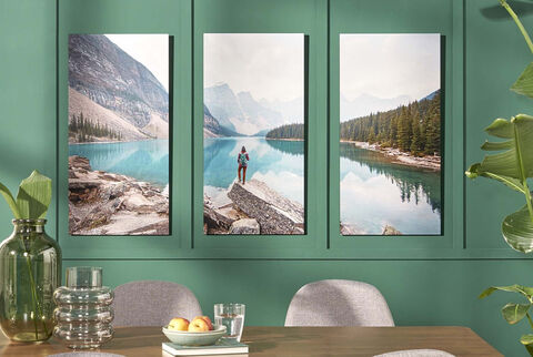 Three stunning landscape pictures on a green wall, showing a hiker by the lake.