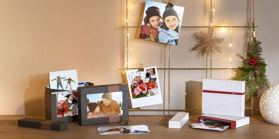 Photo prints and gifts on a table with illuminated decor.