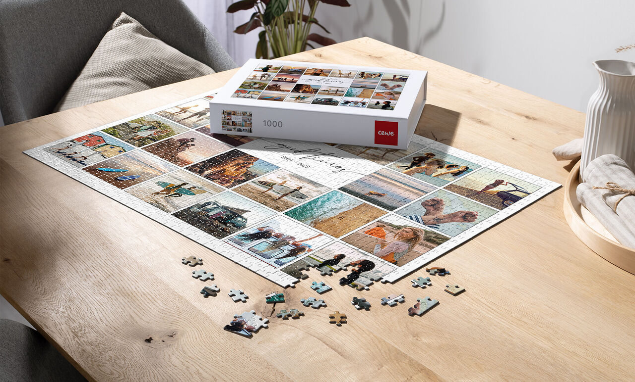 A 1000-piece puzzle with many images on a wooden table, some pieces lying aside