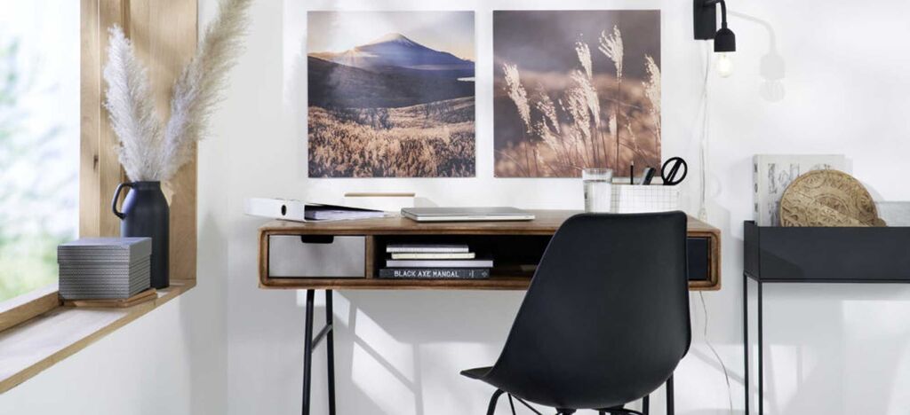 Stylish home office with a black chair and pictures.