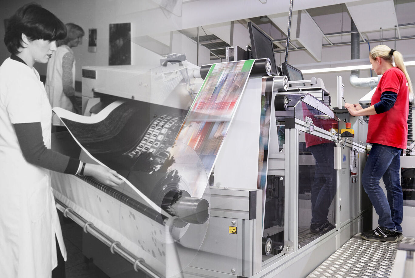 An employee at CEWE works on large-format prints while another holds a roll of paper.