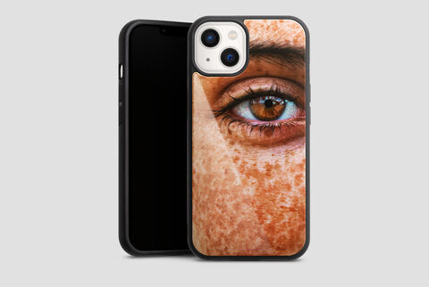 Close-up of a human face with freckles and brown eye, smartphone case beside the face