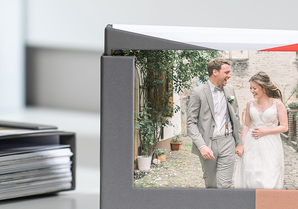A couple in elegant wedding dresses holds hands and walks through a picturesque garden.