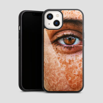 Close-up of a pair of eyes on a phone case showing a person with freckles