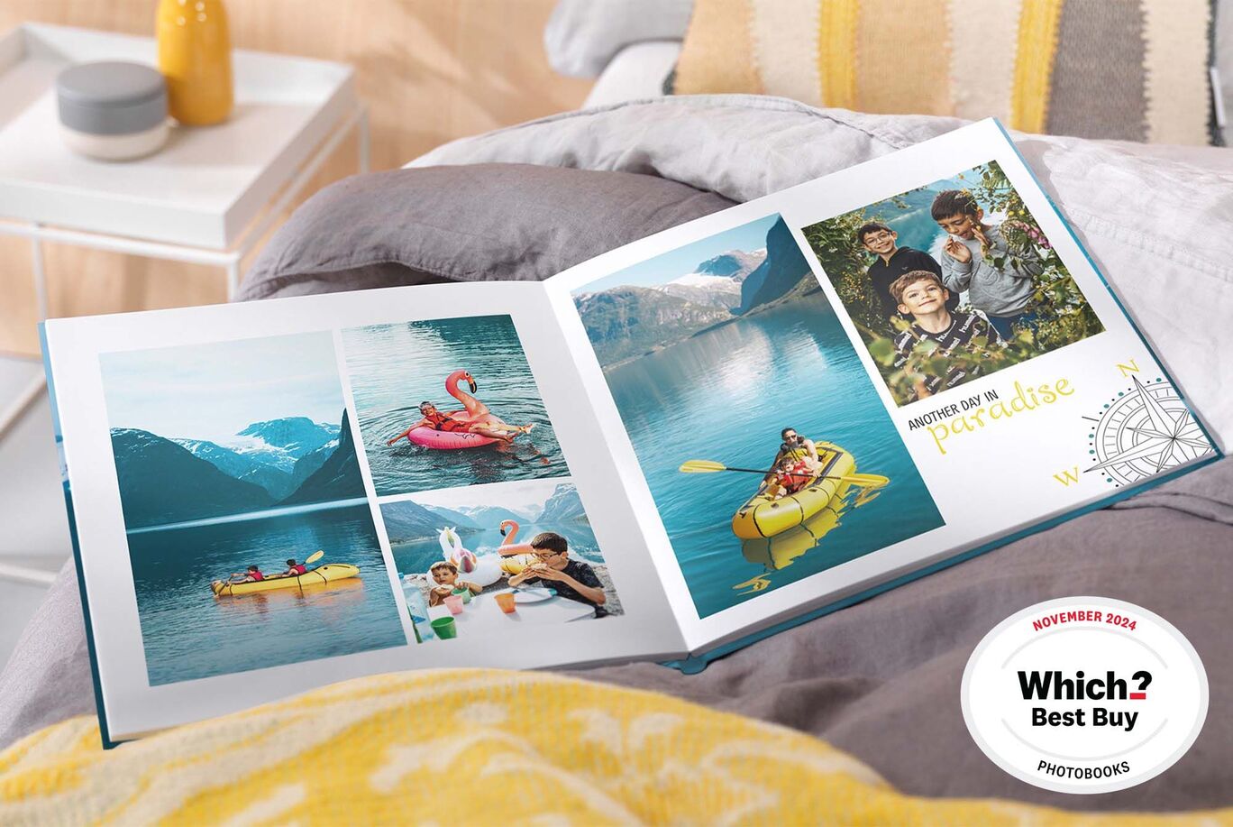 An opened CEWE PHOTO BOOK on a bed shows memories of water adventures with colorful pictures of family and friends kayaking and relaxing.