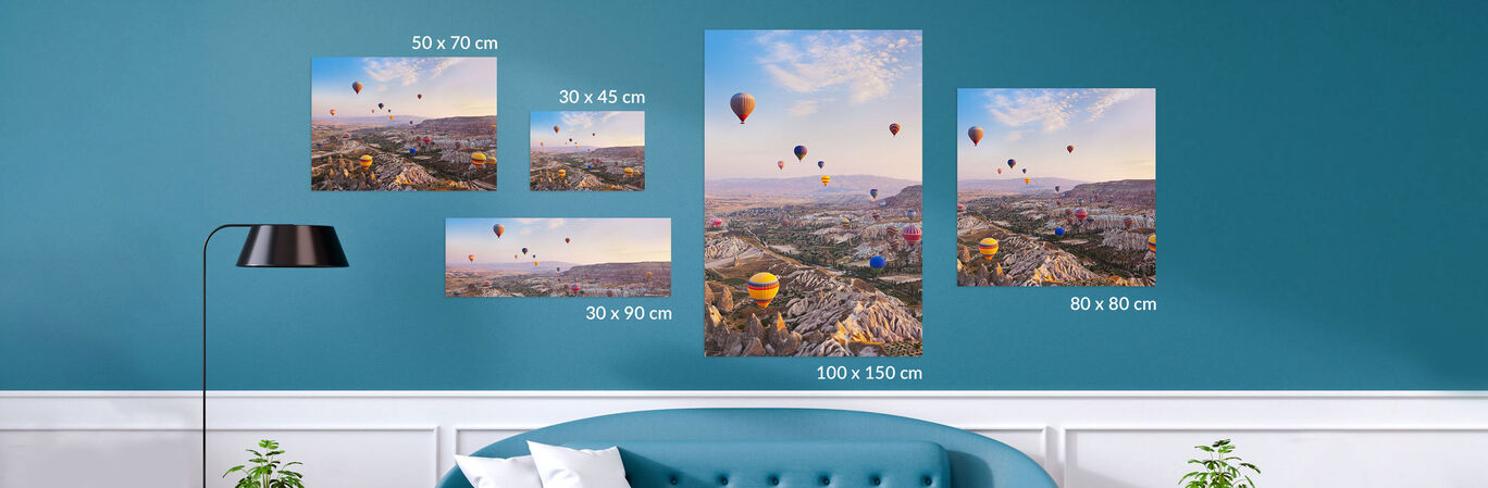 Various pictures of hot air balloons over a beautiful landscape are harmoniously arranged on a wall.
