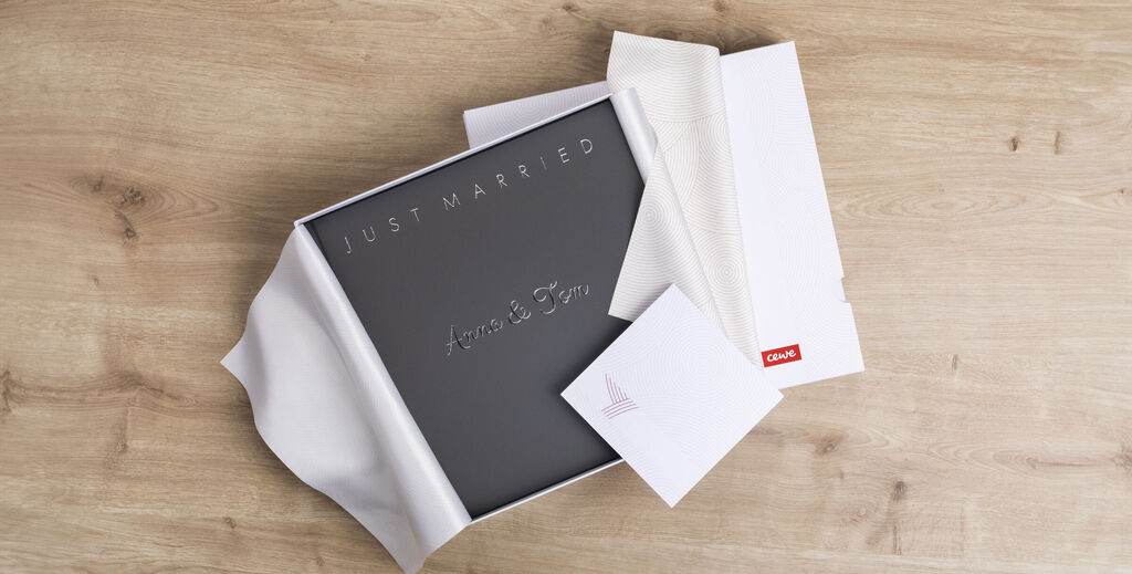 A newly delivered CEWE PHOTOBOOK in an elegant gift box with an envelope.
