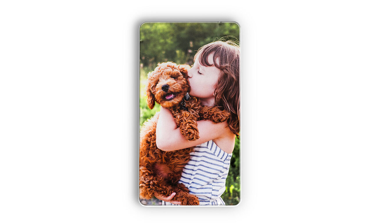 A happy puppy being hugged by a child.