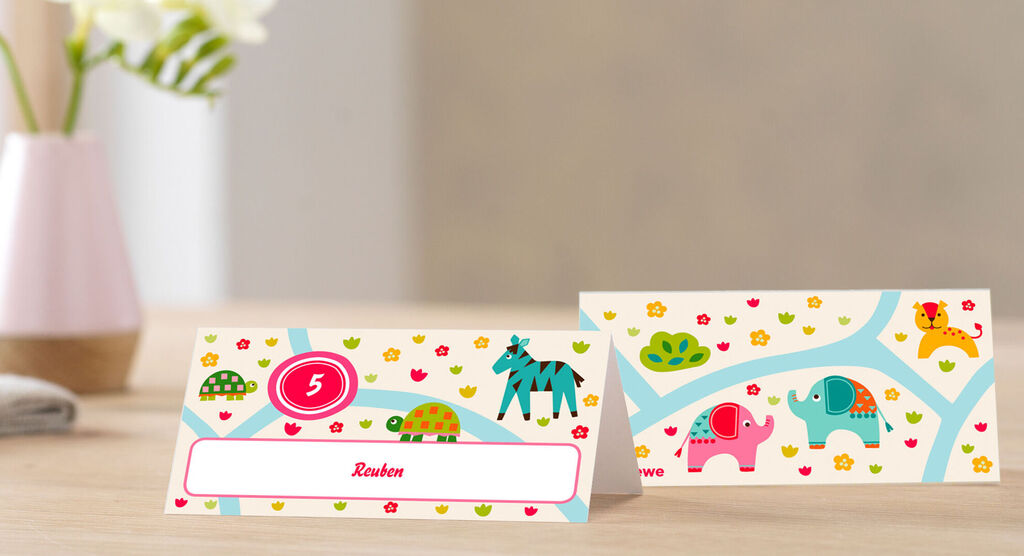 A place card design for children with colorful animal motifs like an elephant, zebra, and lion.