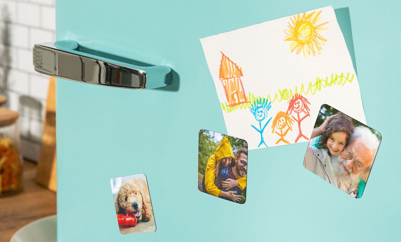 Colorful photos and a drawing are on the refrigerator.