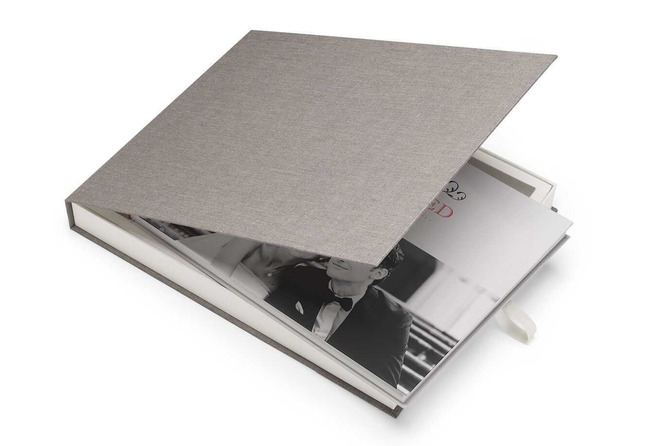 An open CEWE PHOTO BOOK with an elegant gray hardcover and a romantic black and white photo inside.