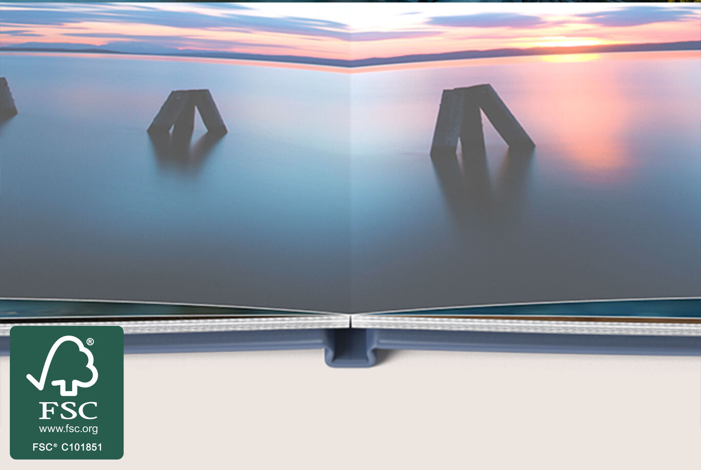 Open pages of a CEWE PHOTO BOOK with a landscape at sunset.