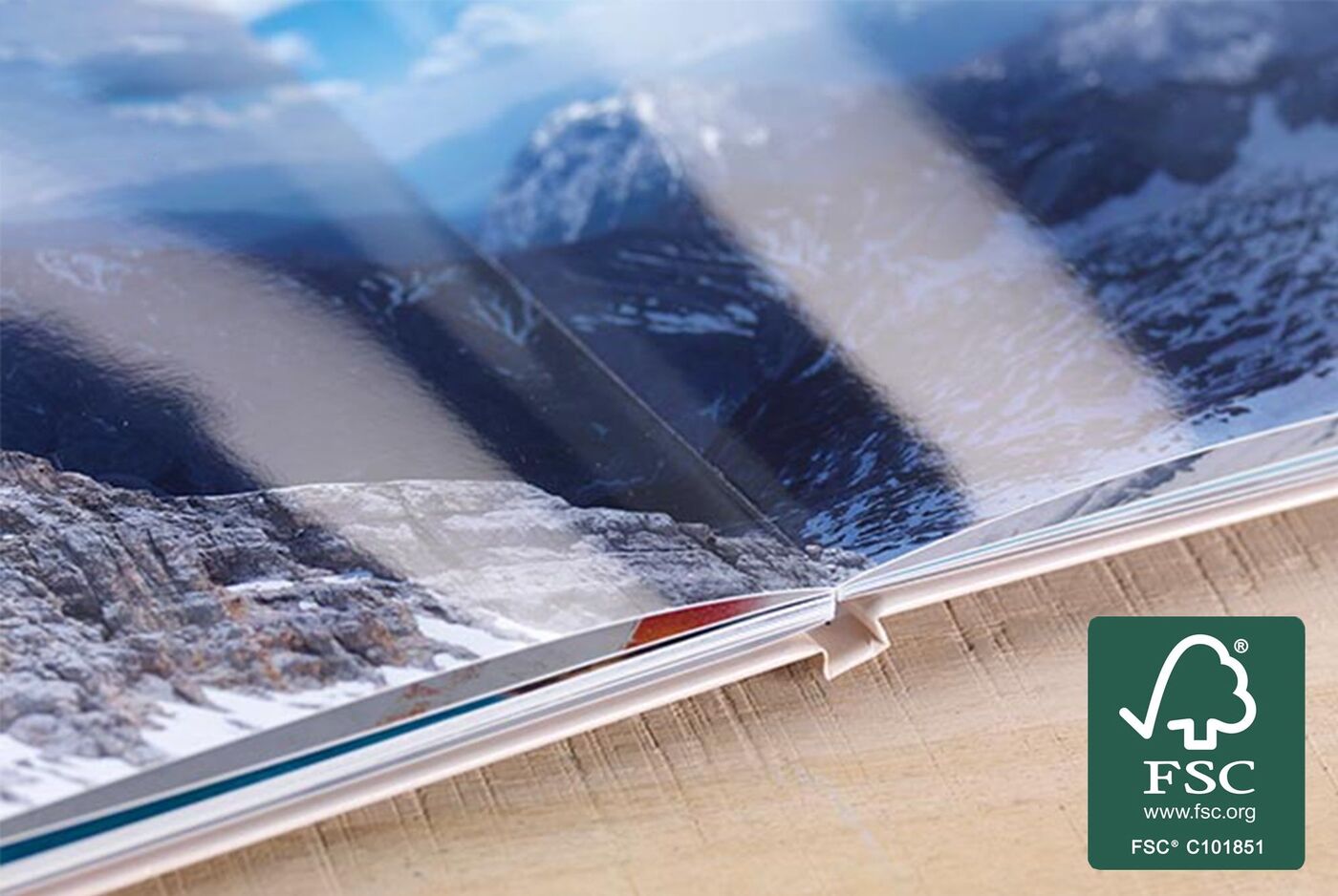 Opened photo book displaying breathtaking mountain landscapes.