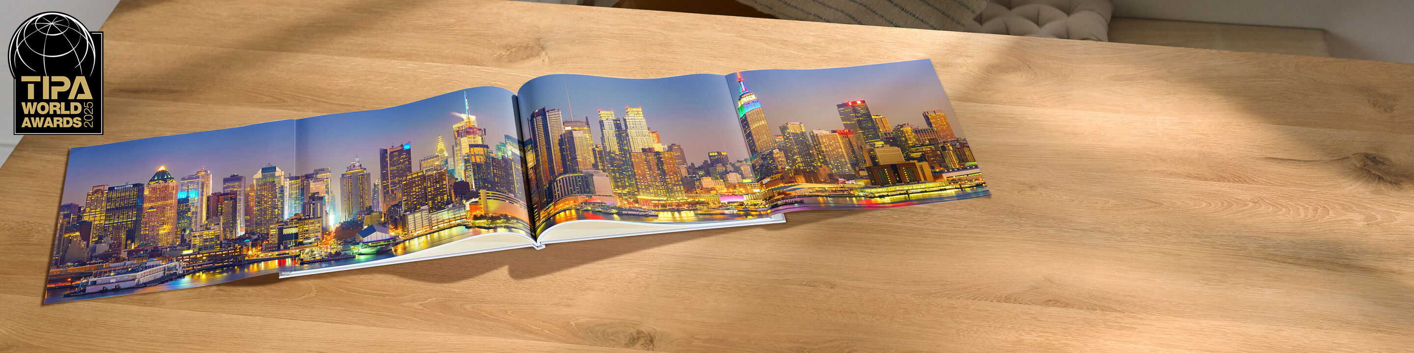 An opened CEWE photo book displays a stunning skyline of Philadelphia at dusk on a table.