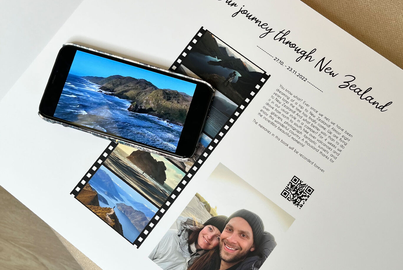 Phone shows images from a New Zealand trip, surrounded by other photos and a QR code