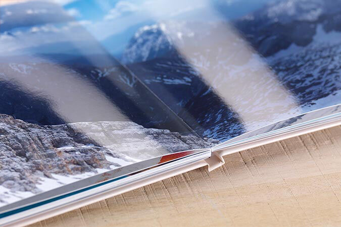 Close-up of an open CEWE PHOTO BOOK showing a beautiful mountain landscape.