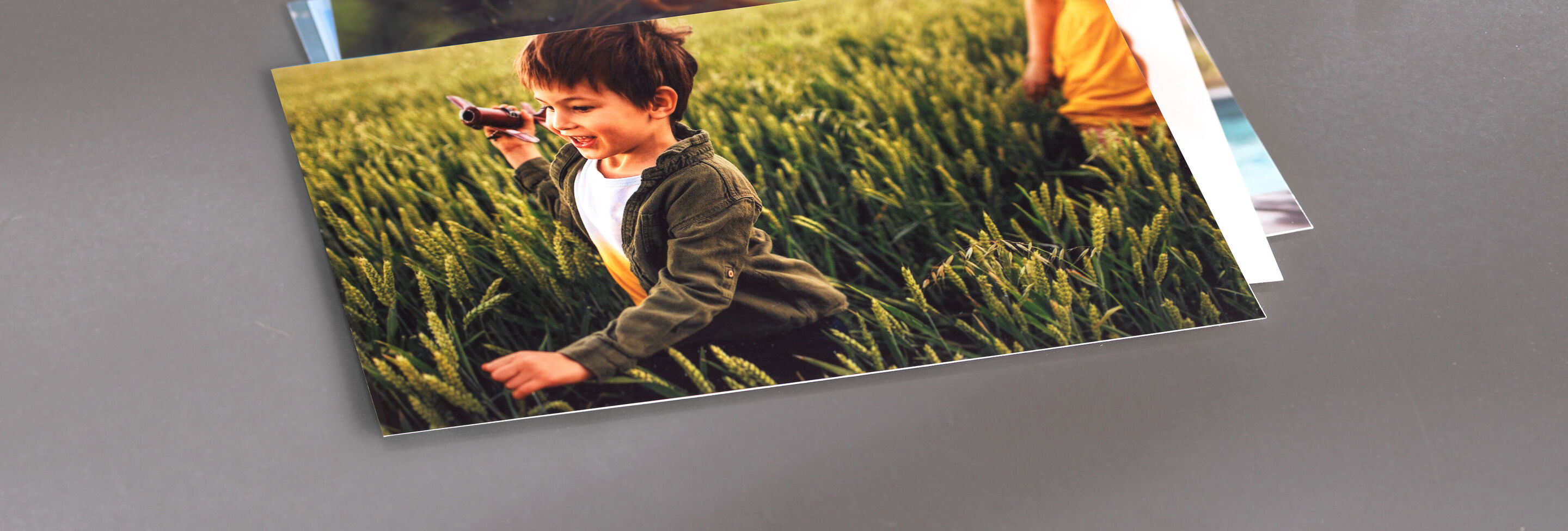 A child runs happily through a green field.