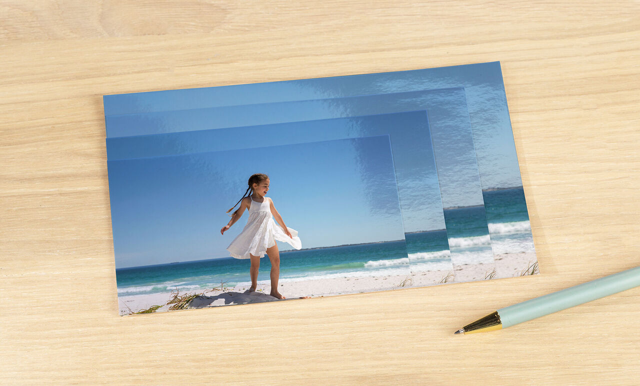 A girl in a white dress stands on the beach, happily looking into the distance.