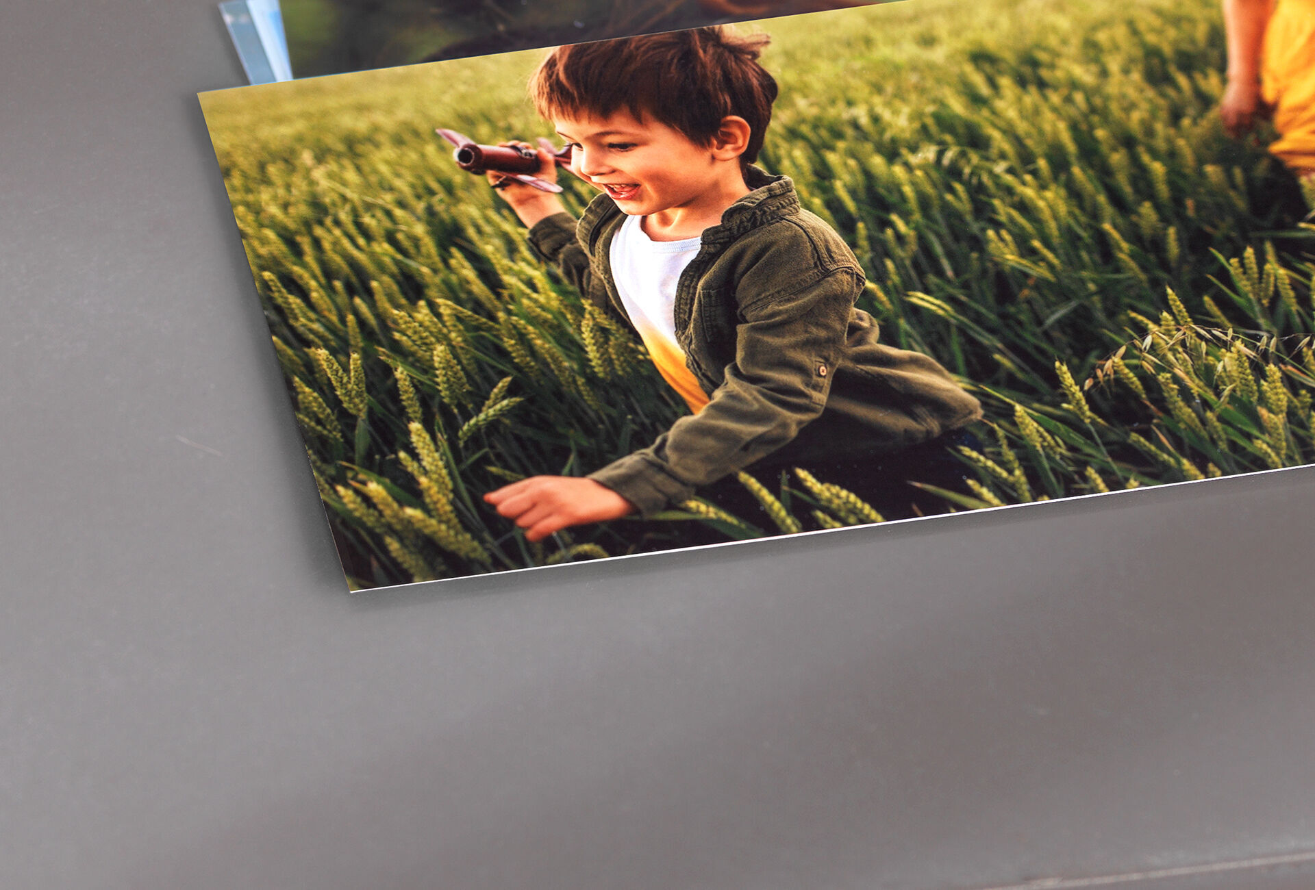 A child with toy in a field full of green grass.
