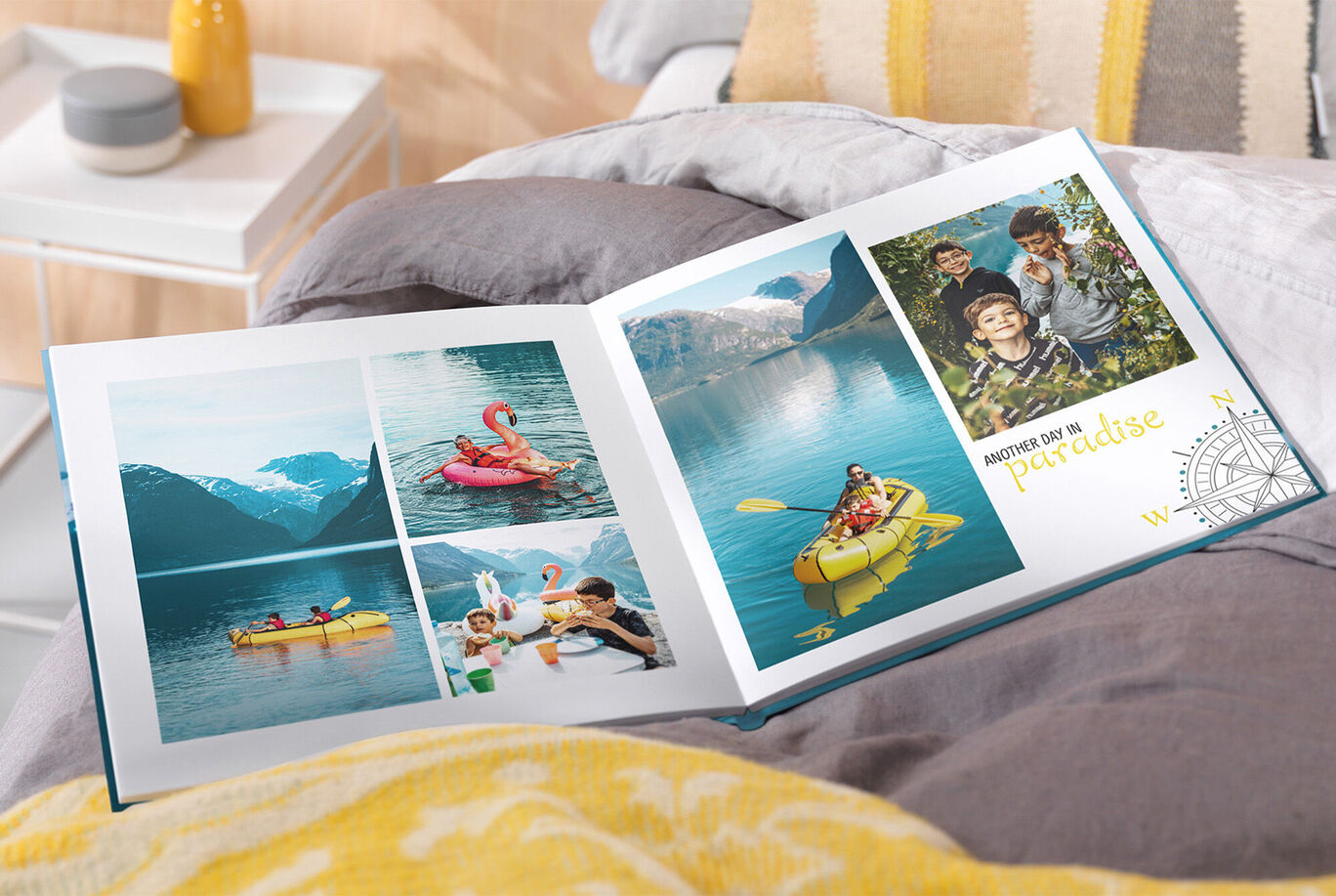 An open photo book on a bed shows vacation memories with pictures of friends by the water and kayaking.