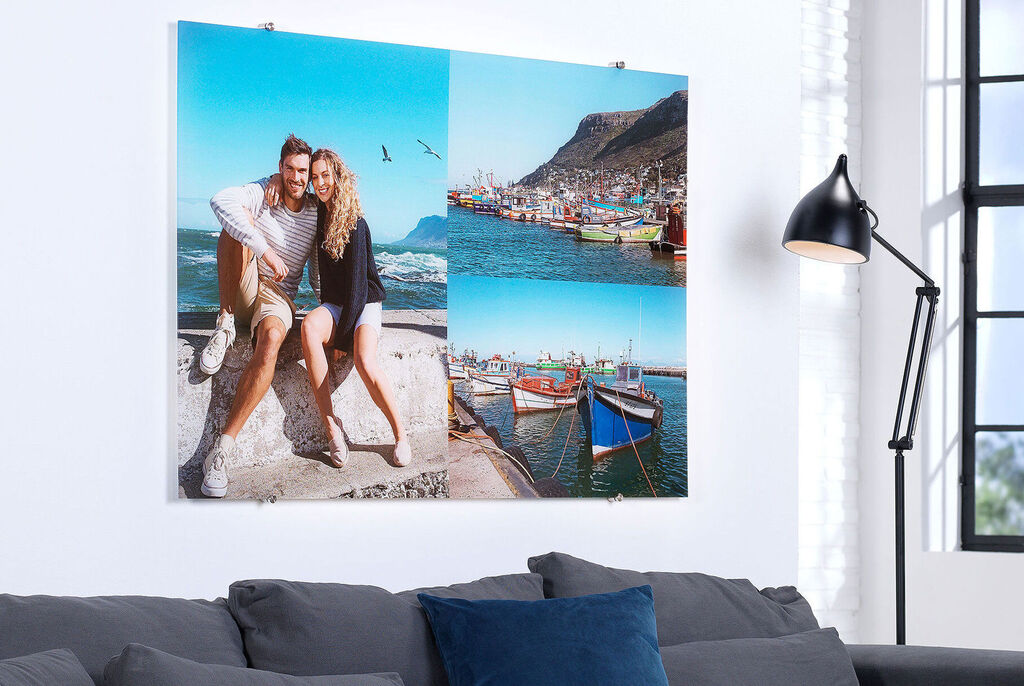 Couple happily posing in front of a wall picture with a maritime motif and colorful boats.