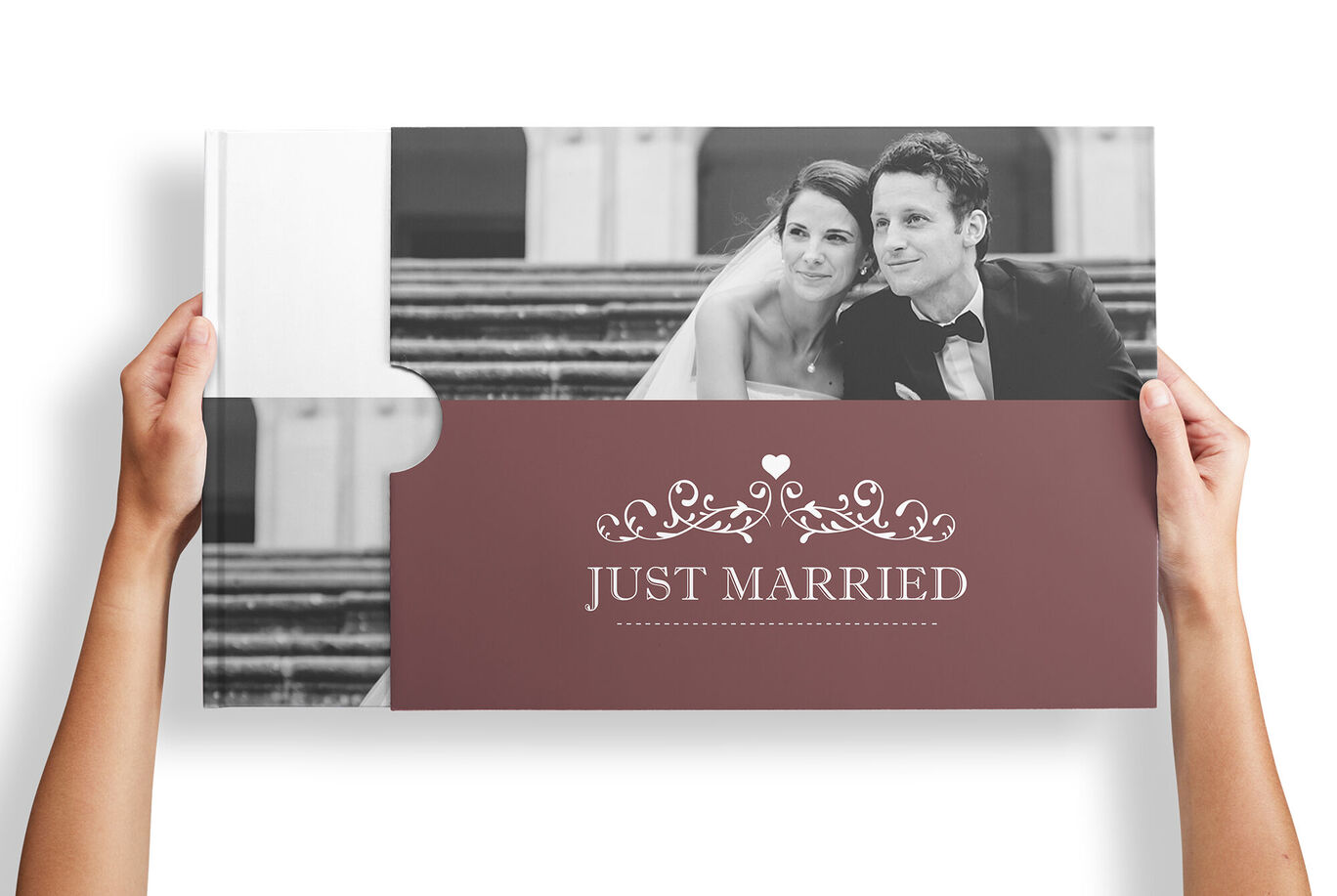 A couple holding a photo book inscribed with 'Just Married'.