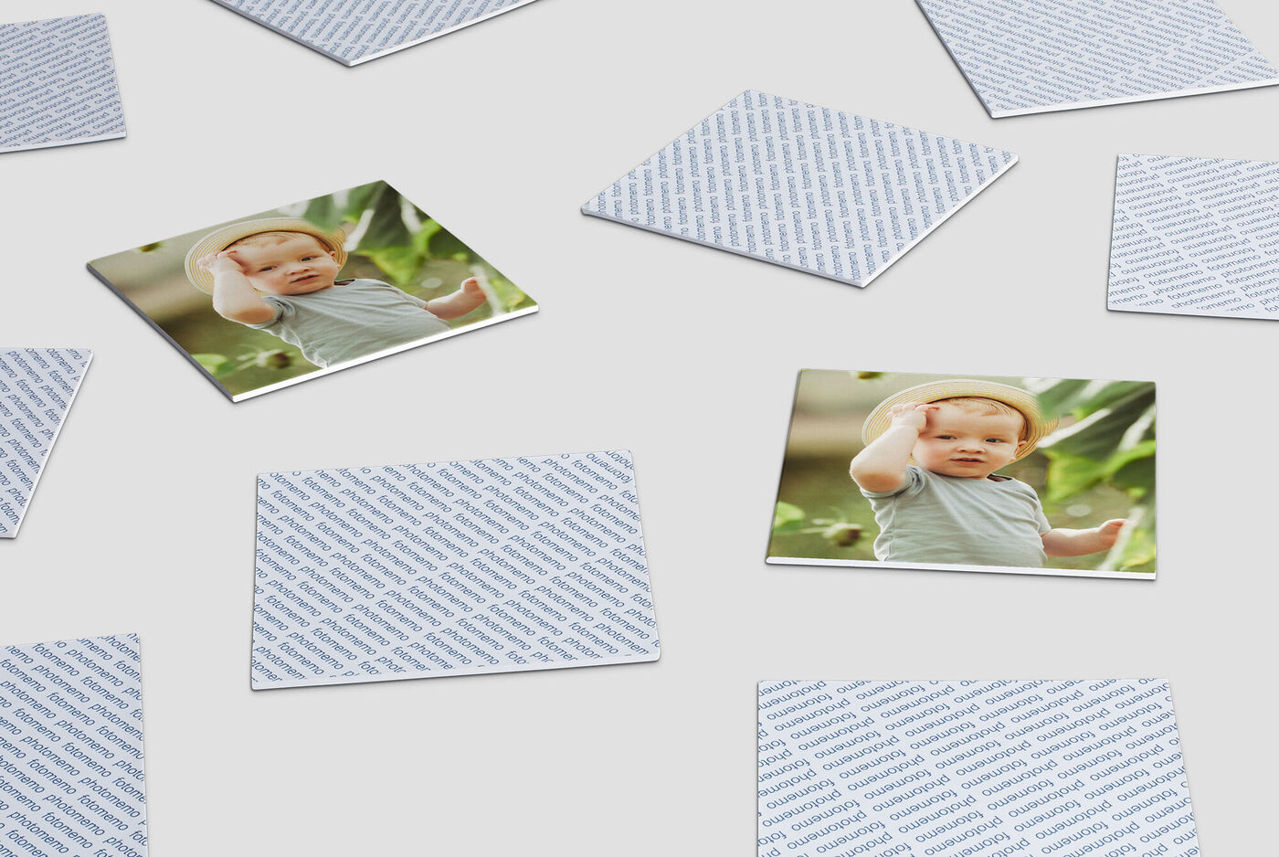 Child lying on a wooden floor among playing cards.