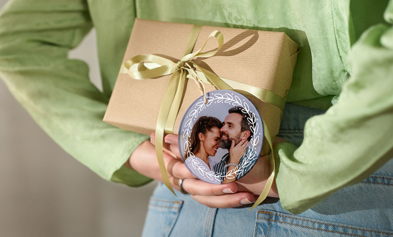 Gift with a bow and a round ornament featuring a picture.