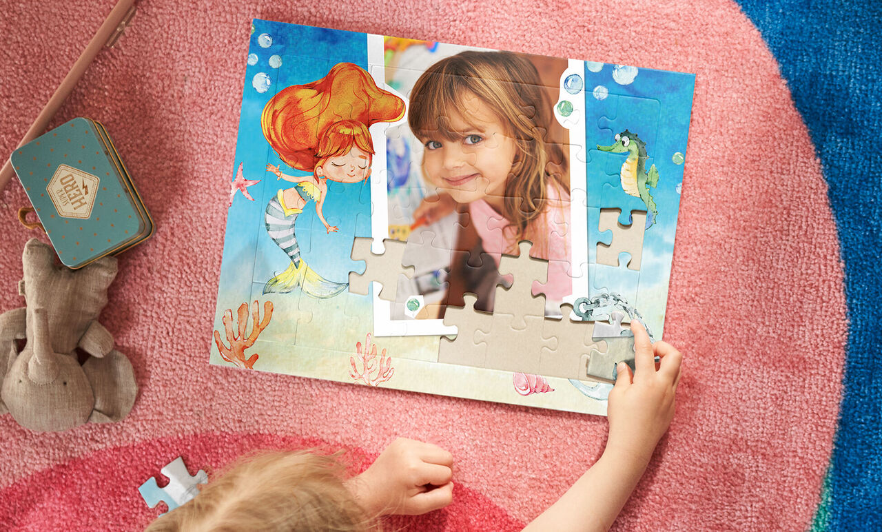 A child puzzles excitedly on a colorful underwater puzzle.