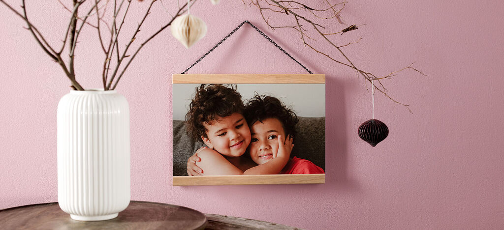 Two children hugging in a frame on a wall