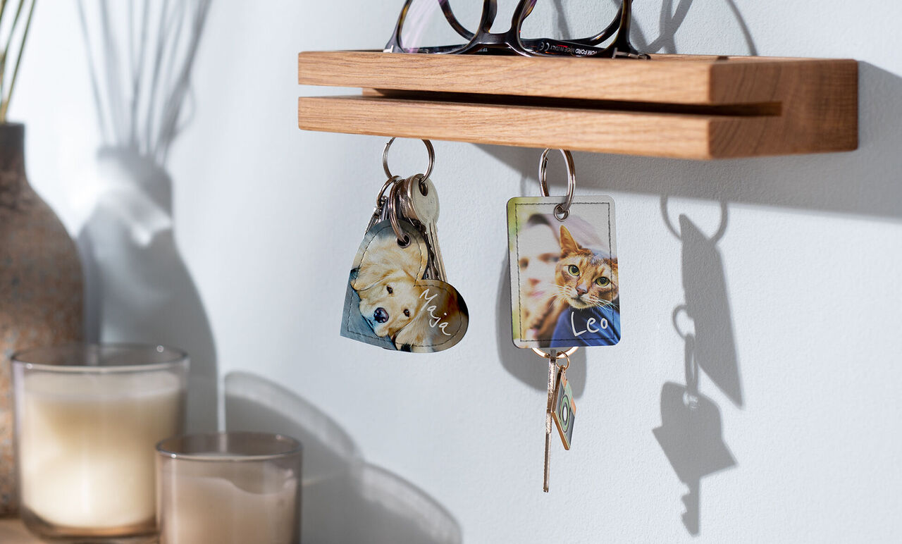Colored keychains hanging on a wooden hook.